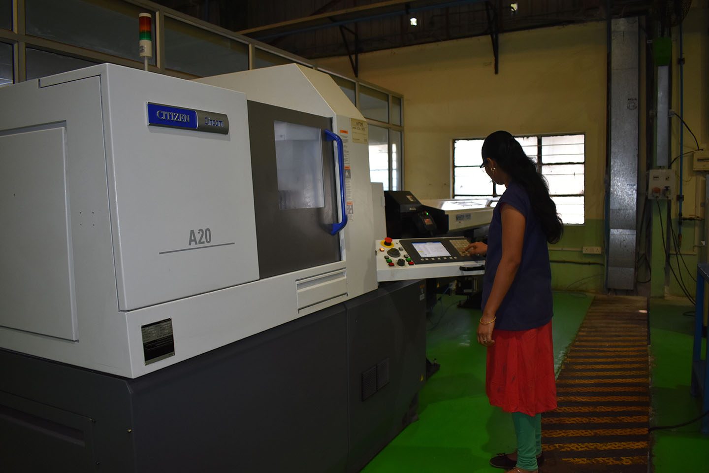 A sliding-head CNC machine at PSCPL, used for small precision turned parts, with an operator at the control