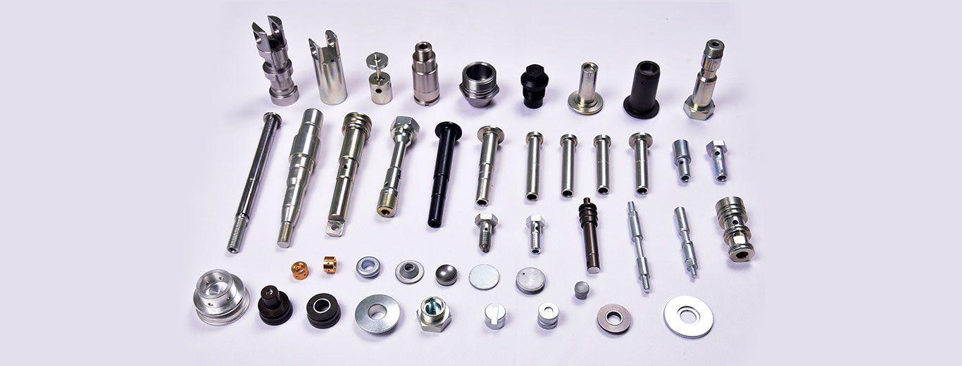 Precision machined automotive components made by PSCPL - shafts, pins, bushes, collars and fasteners laid out on a light surface